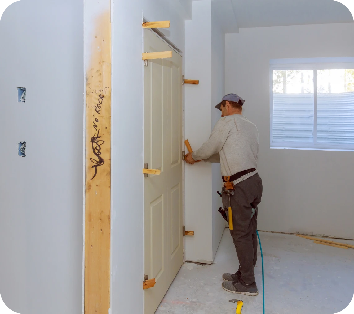 Construction worker aligning door frame